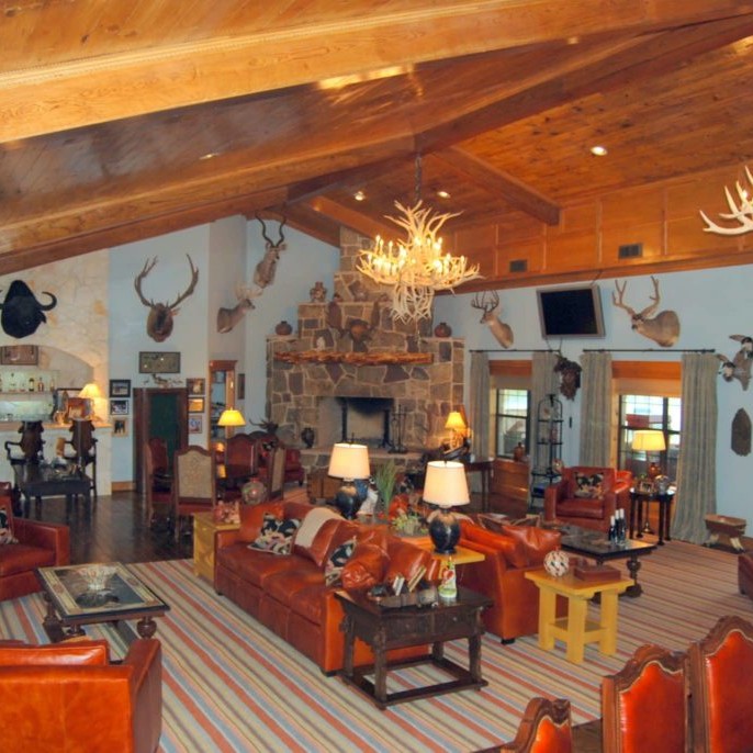 Rustic family room interior design of a cabin with deer antler chandeliers
