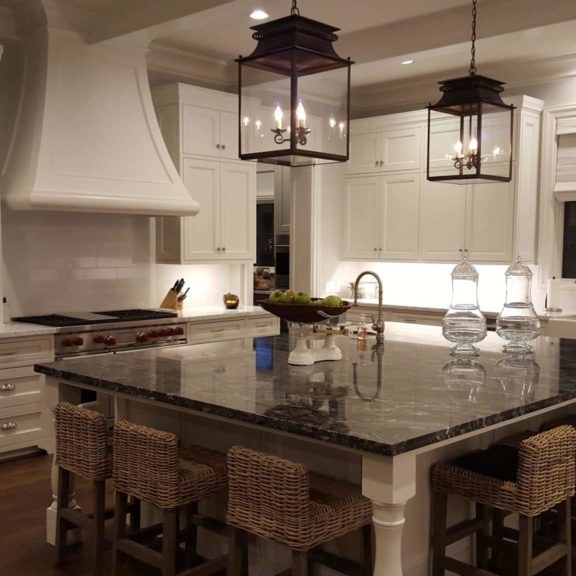 Kitchen interior design with large marble island and wicker seating