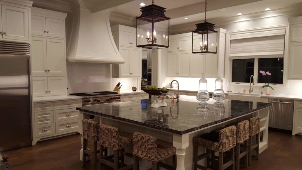 Kitchen interior design with large marble island and wicker seating