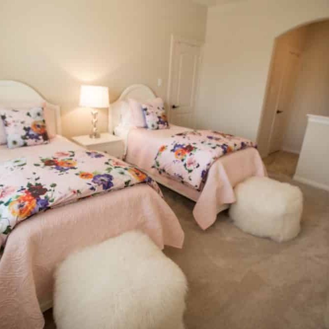 White bedroom design with pink floral twin beds