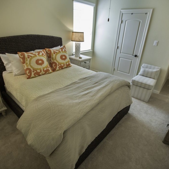 White bedroom interior design with orange and yellow accent pillows