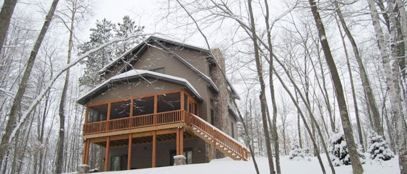 Exterior of a lake house on snow covered grounds