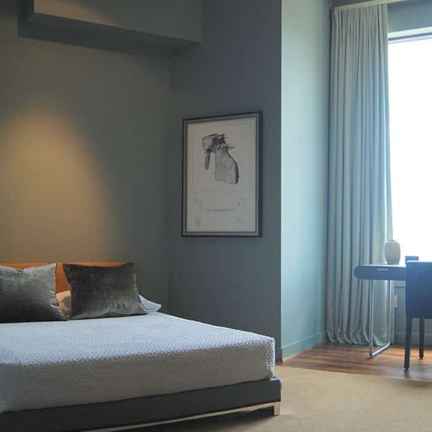 Gray and blue bedroom interior design with a large window