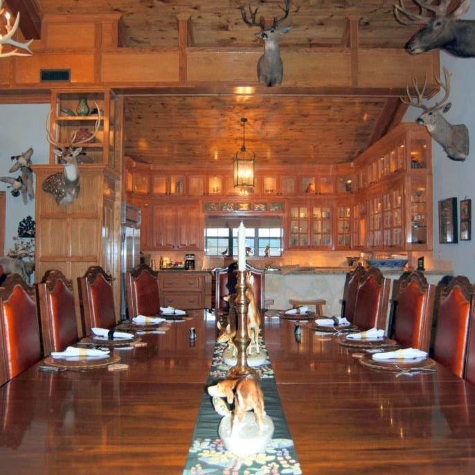 Rustic cabin-style dining room interior design with deer heads mounted on the wall