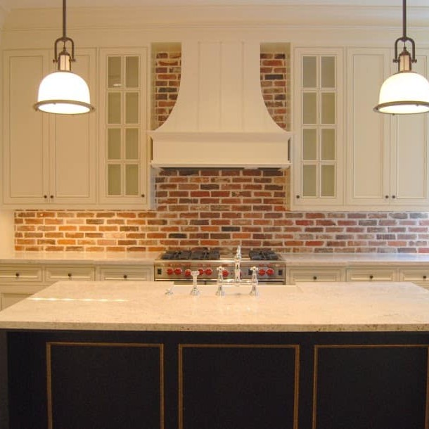 Kitchen interior design with brick backsplash and marble island