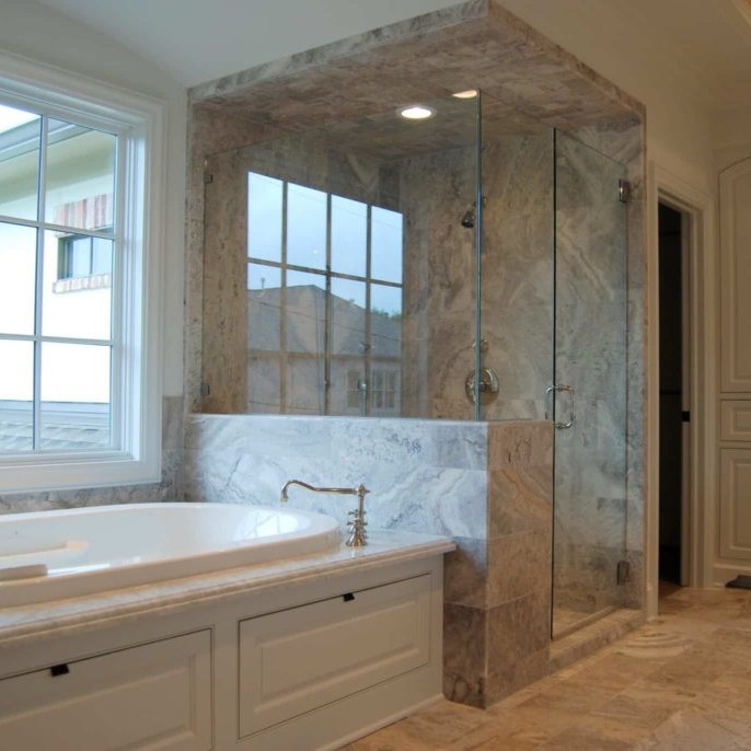 Luxurious bathroom design with marble bathtub and glass shower doors