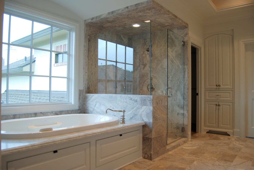 Luxurious bathroom design with marble bathtub and glass shower doors
