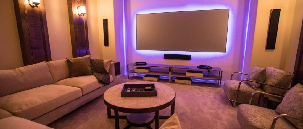 Media room design with purple backlit TV and sectional sofas