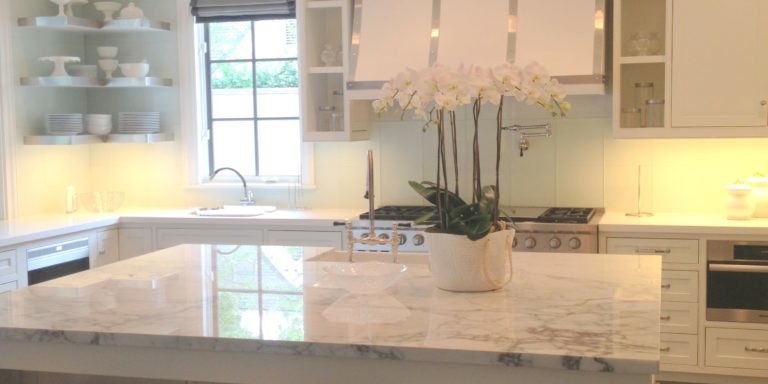 Light-colored kitchen interior design with gray marble island
