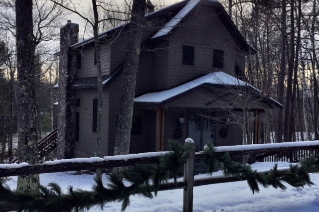 Exterior of a lake house surrounded by snow