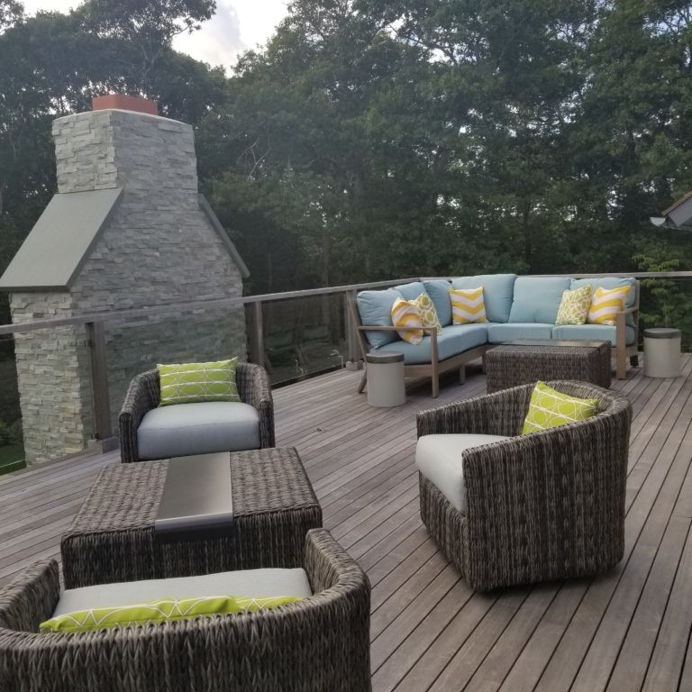 Upper-level deck with gray wicker chairs and sofa