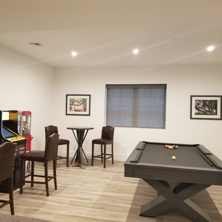 Game room design in Hamptons, NY, with arcade machines and a pool table