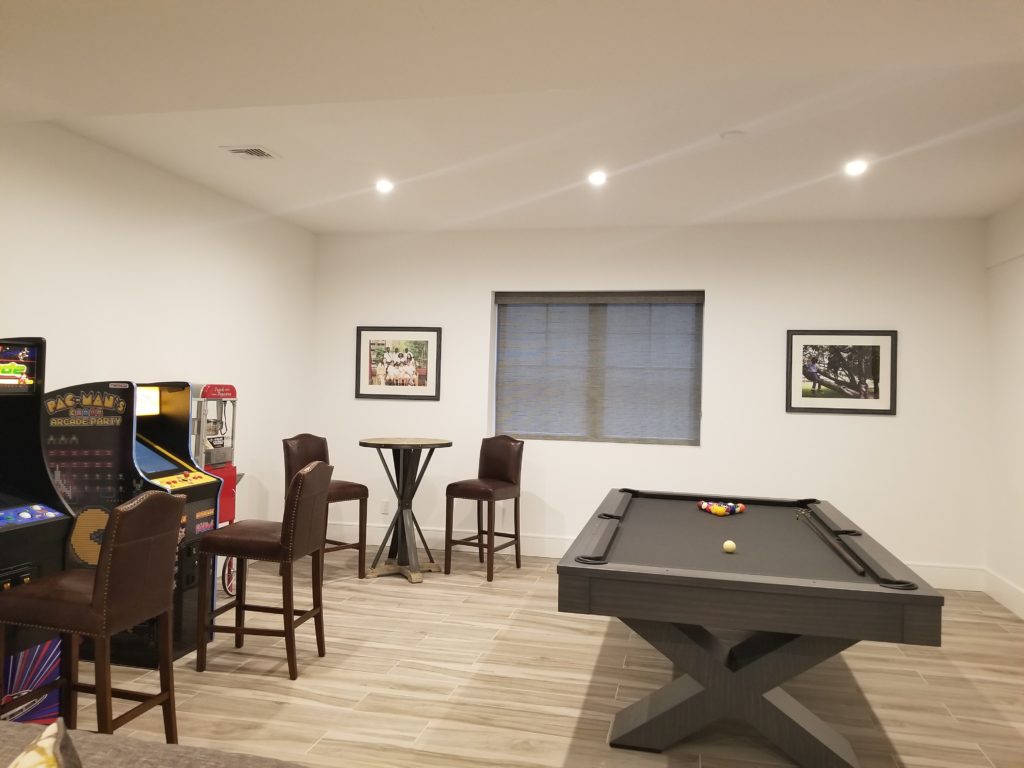 Game room design in Hamptons, NY, with arcade machines and a pool table