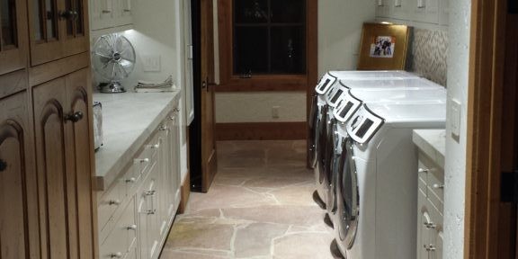 Modern lodge-style laundry room with ceruse-finished cabinetry