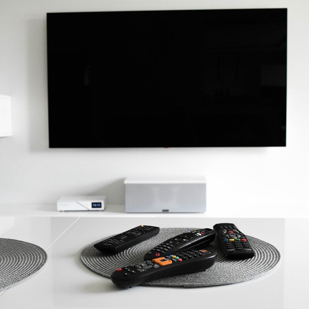 Home media room TV with remote controls on a table