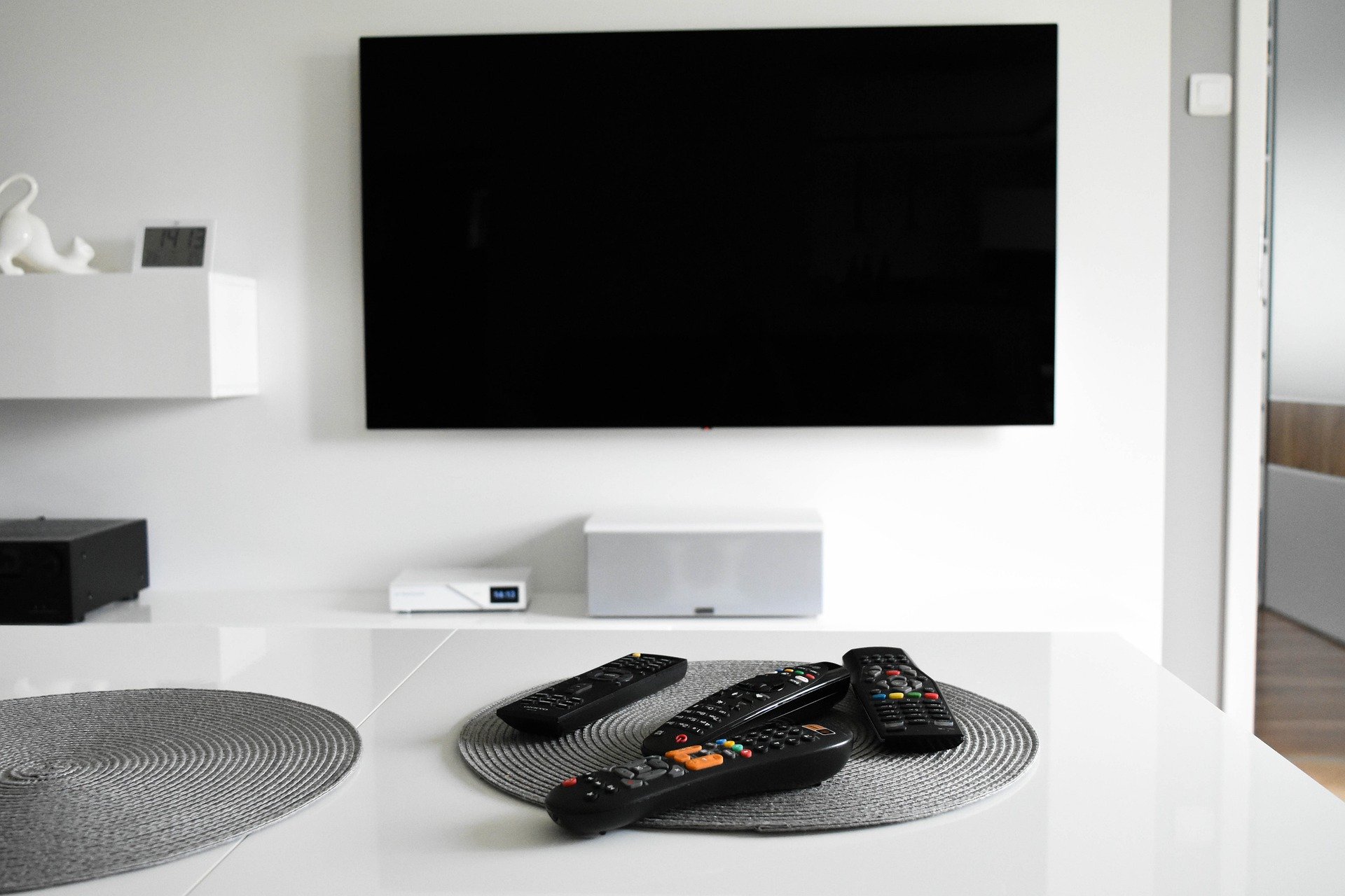 Home media room TV with remote controls on a table